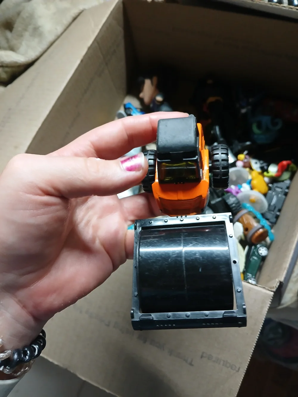 die-cast orange road roller toy Maisto